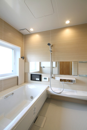 浴室は温かみのある木材の壁と浴槽の白がマッチしています。