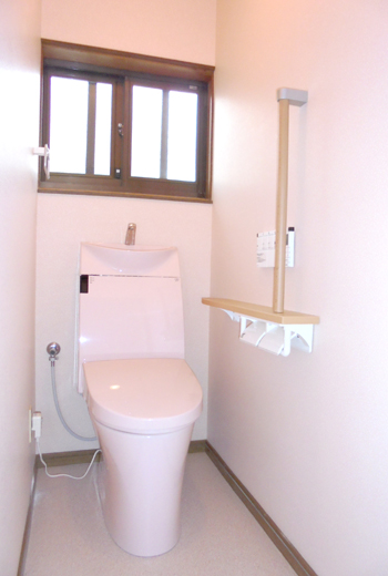 LIXILのすっきりとしたデザインの節水型便器に交換しました。手摺り付きの紙巻器も設置して使い勝手の良いトイレ空間に。