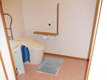 タンクレスのウォシュレット付きトイレです。暖色の壁と床が明るい雰囲気を醸し出しています。